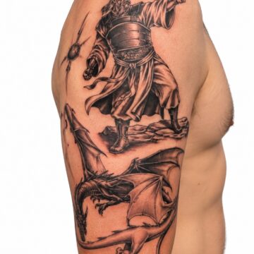 Black and grey warrior and dragon upper arm tattoo – Primitive Tattoo Perth
