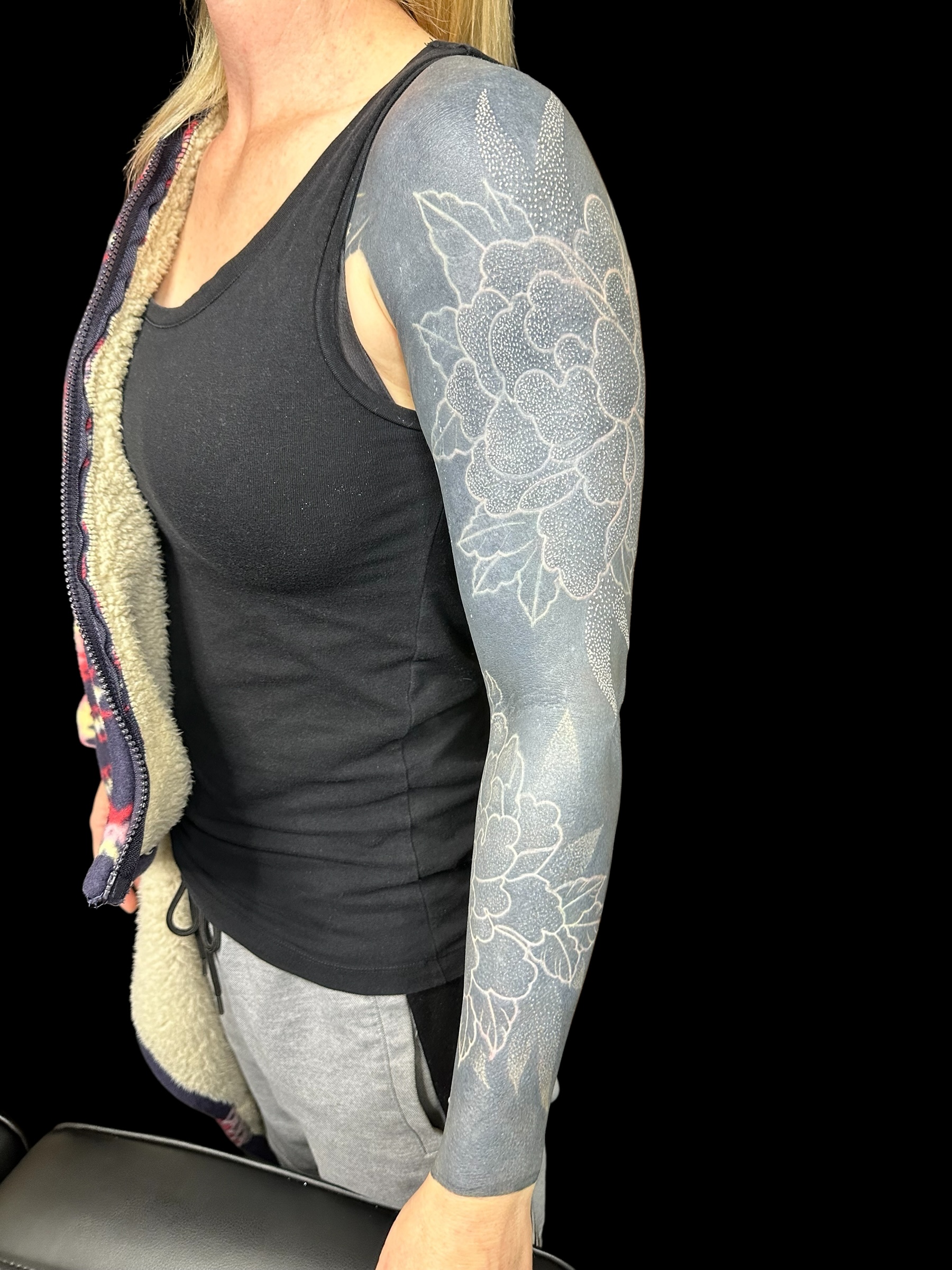Blackout cover-up sleeve with white peonies over old tattoos – cover-up tattoo studio in Perth, Western Australia